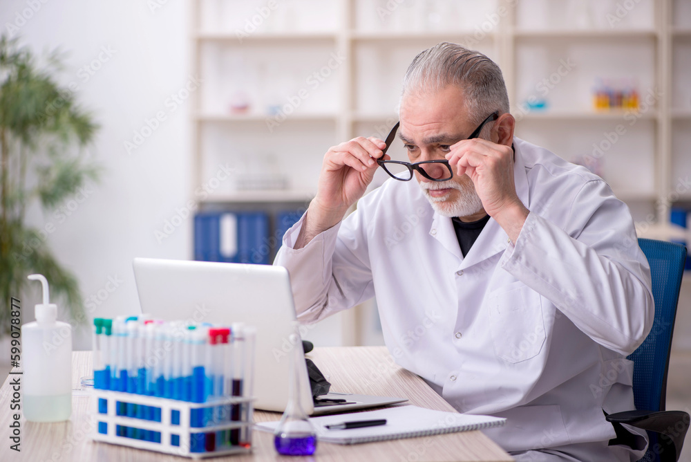 Old male chemist working at the lab Old male chemist working at the lab