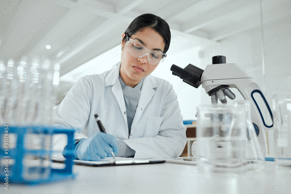 Proving my hypothesis correct. a young woman making notes in her lab. Proving my hypothesis correct. a young woman making notes in her lab.