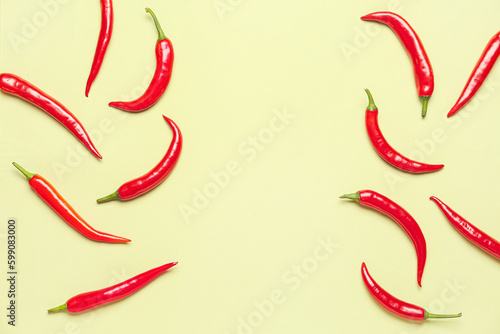 Fresh hot chili peppers on pale yellow background