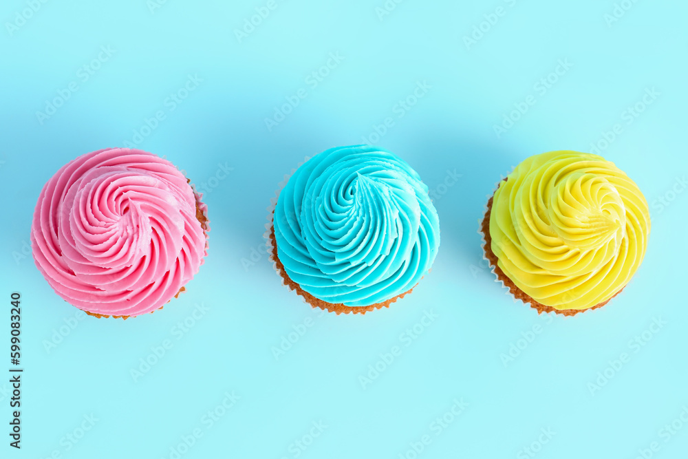 Tasty colorful cupcakes on blue background Tasty colorful cupcakes on blue background