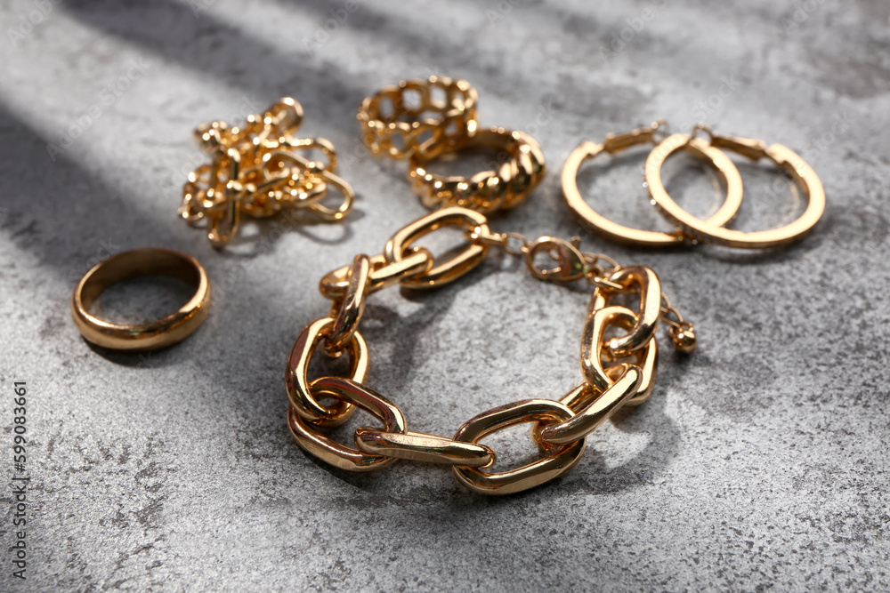 Different beautiful jewellery on grey grunge background Different beautiful jewellery on grey grunge background