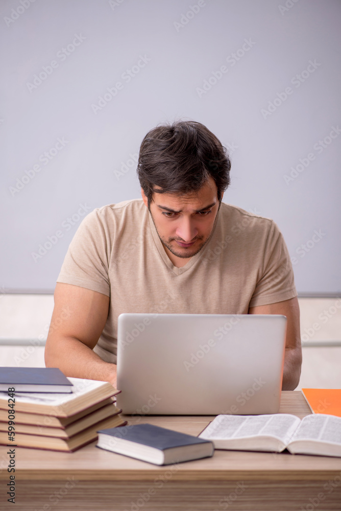 Young male student in tele-education concept Young male student in tele-education concept