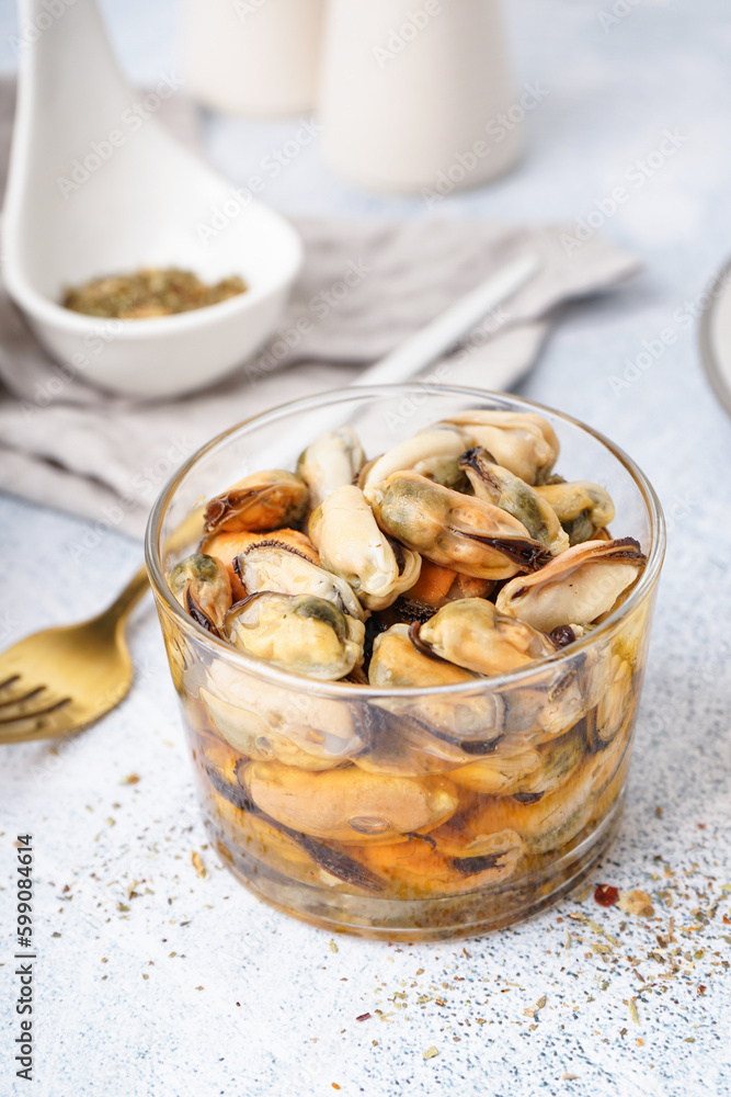 Glass bowl with pickled mussels on grey background Glass bowl with pickled mussels on grey background