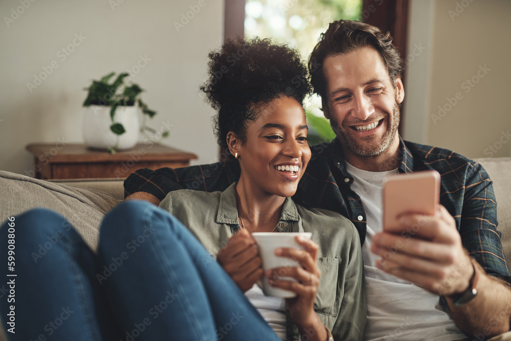 Look at whats trending online today. a happy young couple using a cellphone together while relaxing on a couch at home. - obrazy, fototapety, plakaty 