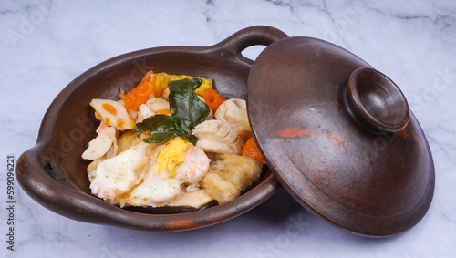 Indonesian street food cuisine, seblak in traditional wok pan, over marble table photo