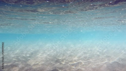 Underwater sandy sea. Water Waves Mixing the sand.Turquoise sea color Rays of sun shining trought the ocean. Caustic Abstract background. Slow motion Seamless loop. 