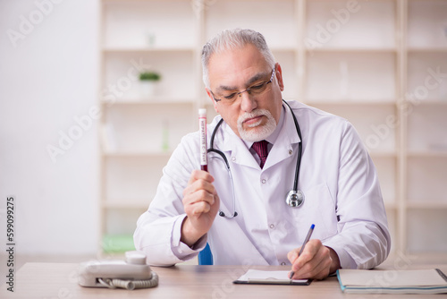 Old male doctor hematologist working in the clinic