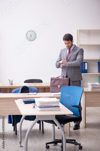 Young male employee in time management concept