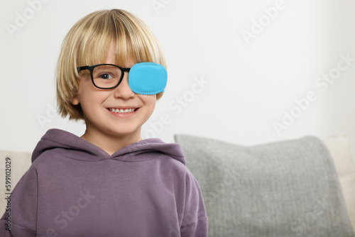 Fotografia Happy boy with nozzle on glasses for treatment of strabismus in room
