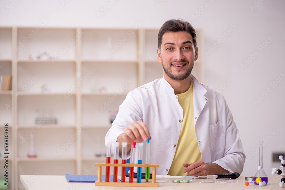 Young male chemist sitting at the lab Young male chemist sitting at the lab