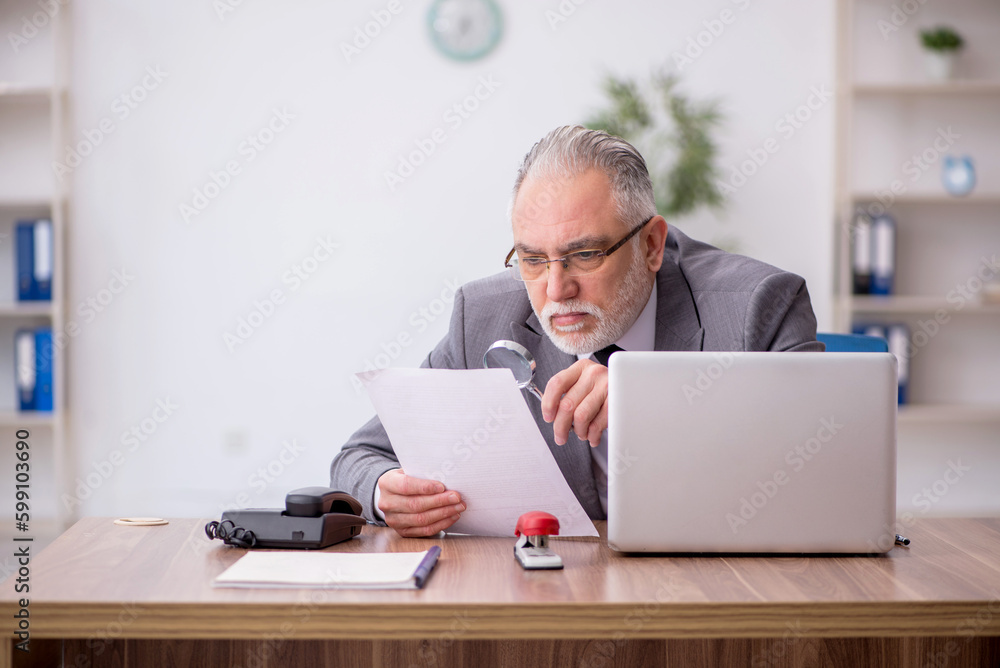 Old male employee working in the office Old male employee working in the office