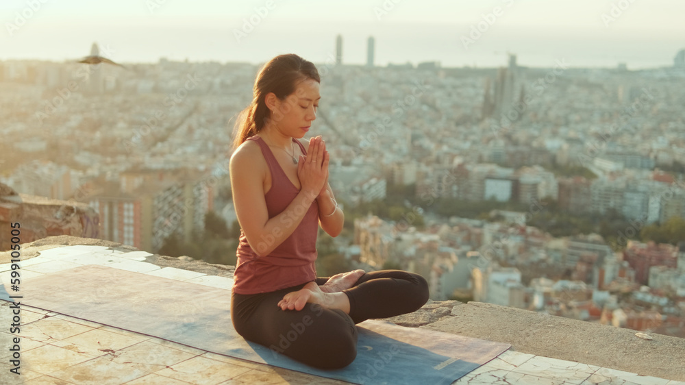 Young woman meditating while sitting in lotus position on the observation deck Young woman meditating while sitting in lotus position on the observation deck