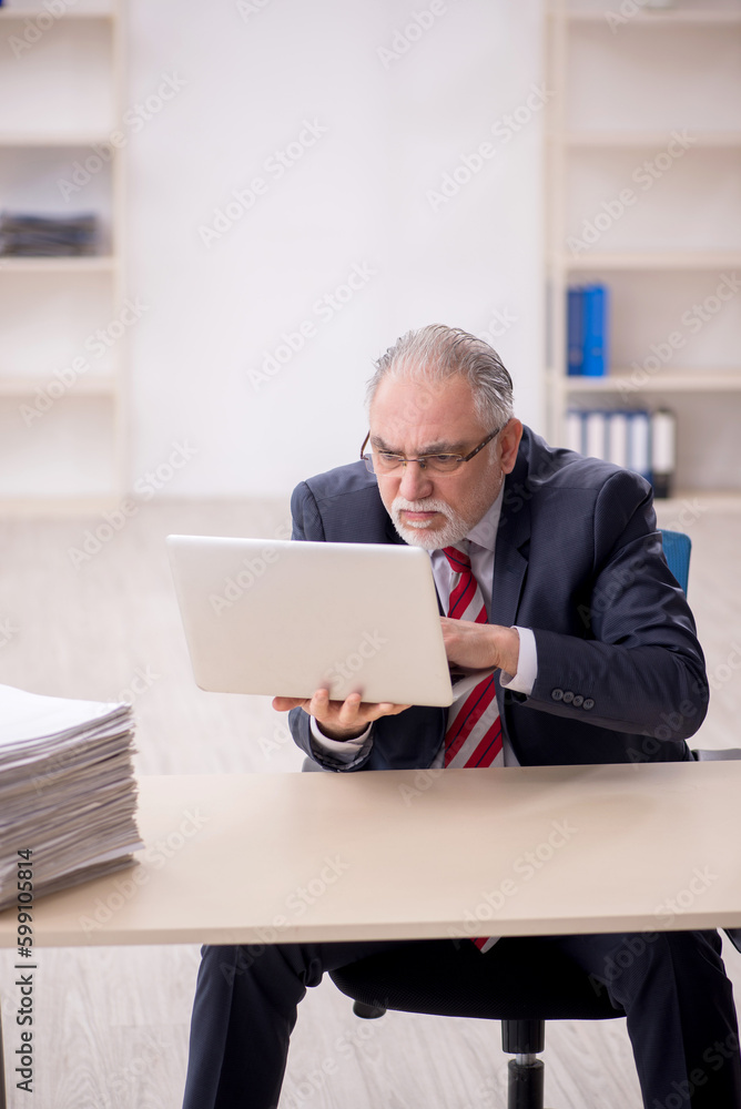 Old male employee and too much work at workplace Old male employee and too much work at workplace