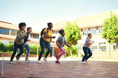 Race you back to class. Full length shot of a diverse group of children running outside during recess at school.