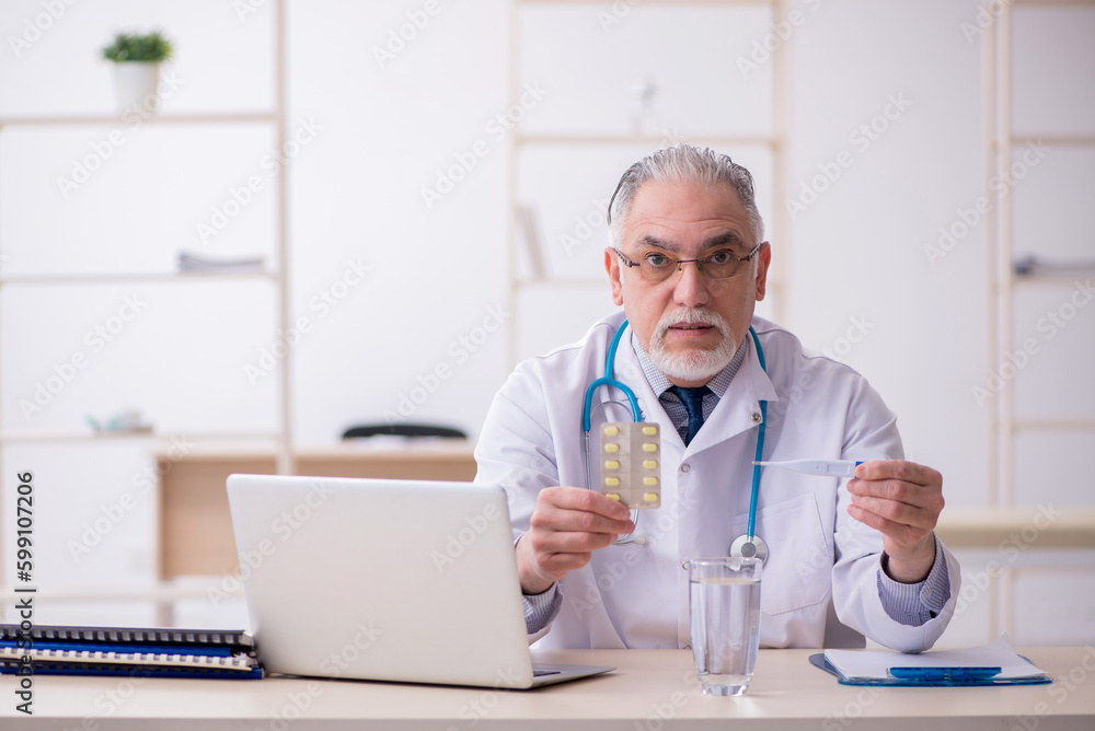 Old male doctor working in the clinic Old male doctor working in the clinic