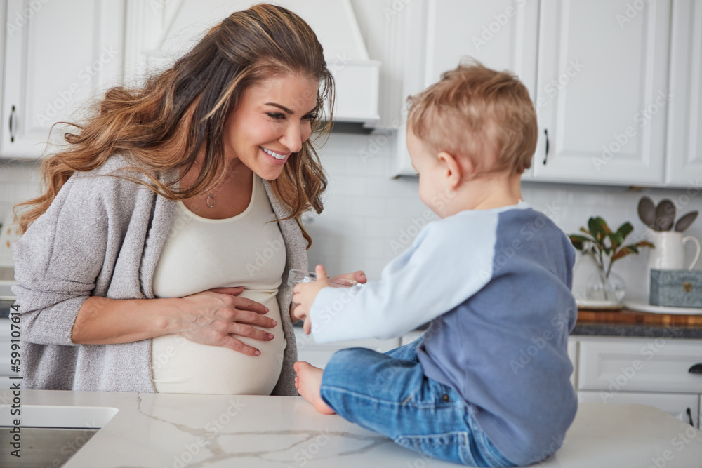 Its snack time. a pregnant woman and her son spending time together in the kitchen at home. Its snack time. a pregnant woman and her son spending time together in the kitchen at home.