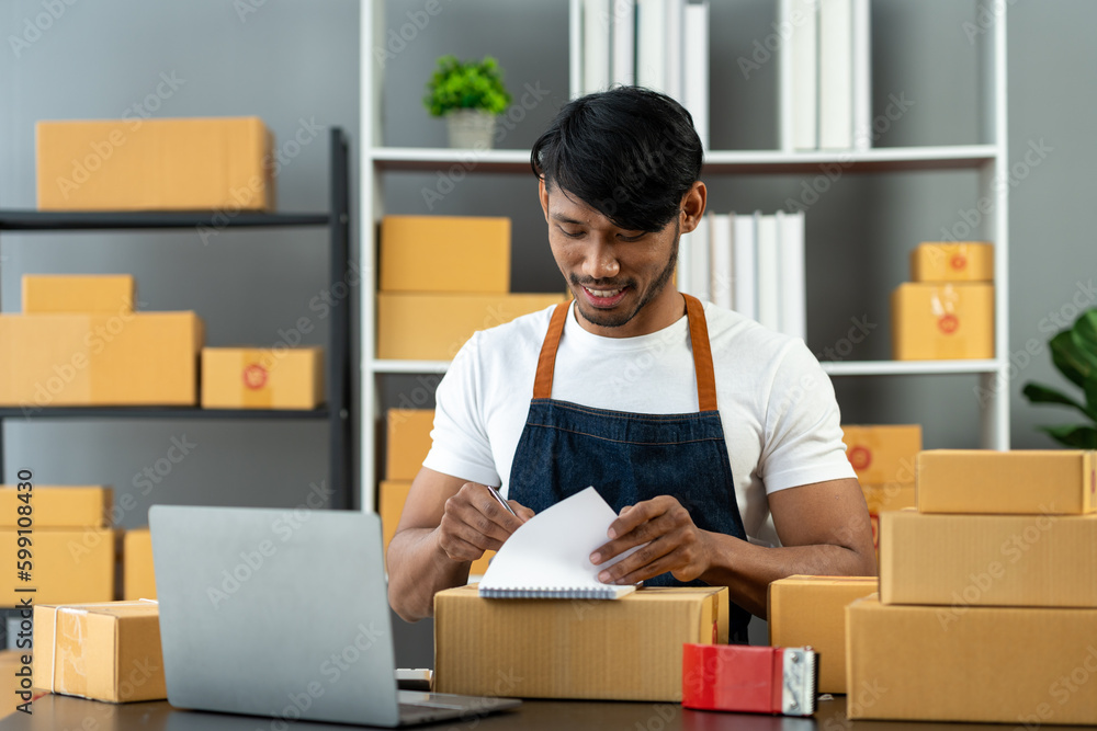 Small Business Entrepreneur SME Male Freelance Working From Home Use laptops and notebooks for commercial auditing. online marketing Packaging boxes, SME sellers, concepts, e-commerce, online sales. Small Business Entrepreneur SME Male Freelance Working From Home Use laptops and notebooks for commercial auditing. online marketing Packaging boxes, SME sellers, concepts, e-commerce, online sales.