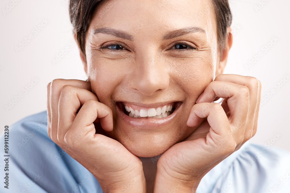 The toothiest of smiles. Cropped portrait of an attractive young woman posing in studio against a grey background. The toothiest of smiles. Cropped portrait of an attractive young woman posing in studio against a grey background.