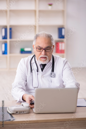 Old male doctor in telemedicine concept