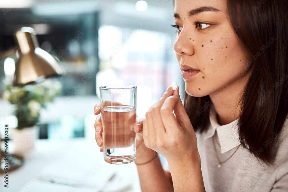 Taking a multivitamin to boost her system. a young businesswoman taking medication in an office. Taking a multivitamin to boost her system. a young businesswoman taking medication in an office.