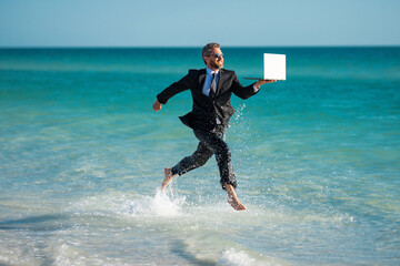 Funny business man in suit on sea. Summer vacation, business on sea beach. Summer rest, business people concept. Business man remote on-line working. Dream for summer vacations office workers.