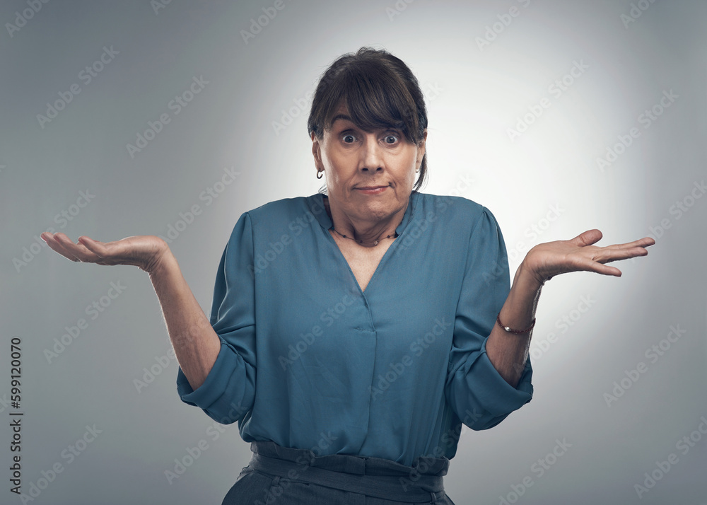 What are you looking at me for. Studio portrait of a senior woman shrugging against a grey background. What are you looking at me for. Studio portrait of a senior woman shrugging against a grey background.