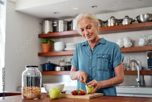 Get your fill of wellness with a healthy breakfast. a mature woman preparing a healthy breakfast in the kitchen at home.