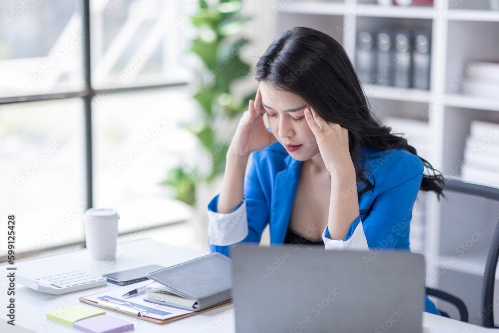 Portrait of tired young business Asian woman work with documents tax laptop computer in office. Sad, unhappy, Worried, Depression, or employee life stress concept Portrait of tired young business Asian woman work with documents tax laptop computer in office. Sad, unhappy, Worried, Depression, or employee life stress concept