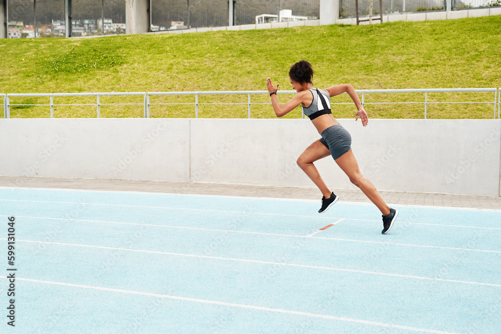 Obraz premium The finish line is my only limit. Full length shot of an attractive young athlete running a track field alone during a workout session outdoors.