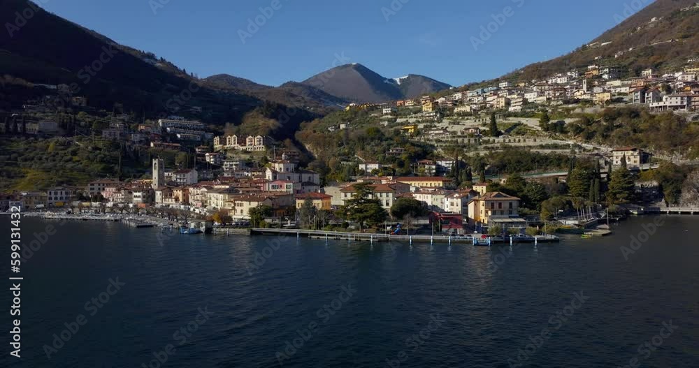 Aerial view of scenic Italian lakeside town and comune, Tavernola Bergamasca, facing the calm turquoise waters of Lake Iseo. Aerial view of scenic Italian lakeside town and comune, Tavernola Bergamasca, facing the calm turquoise waters of Lake Iseo.
