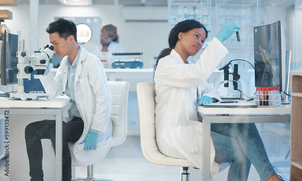 Concentration is at its peak. a young lab technician analysing a test tube sample. Concentration is at its peak. a young lab technician analysing a test tube sample.