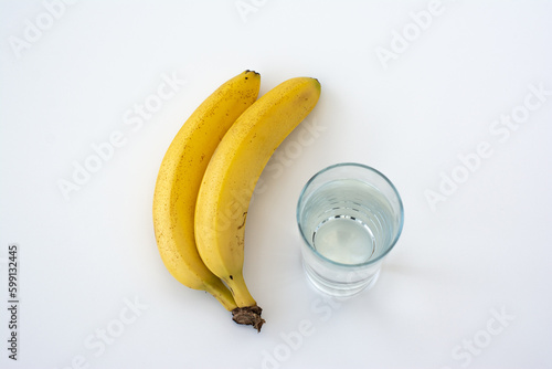Banana and glass of water isolated on white background