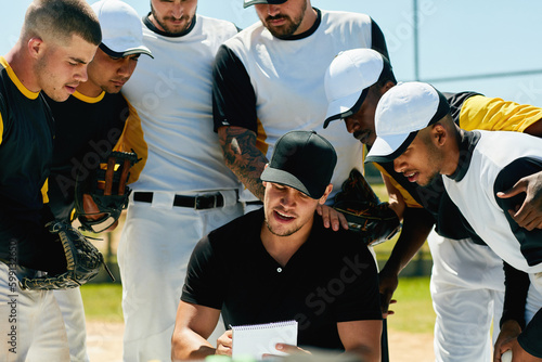 Heres our plan for todays game...a group of young baseball players having a meeting with their coach on the field during the day. photo