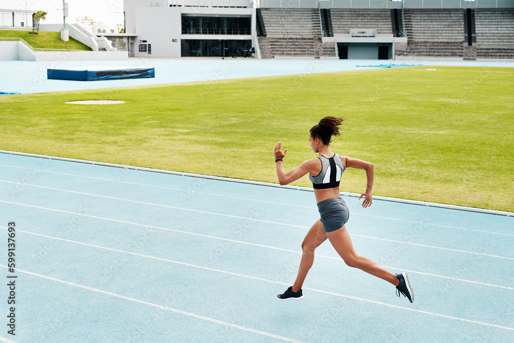 Running is a passion. Full length shot of an attractive young athlete running a track field alone during a workout session outdoors.