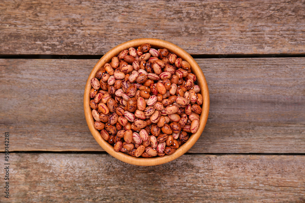 Bowl with dry kidney beans on old wooden table, top view Bowl with dry kidney beans on old wooden table, top view