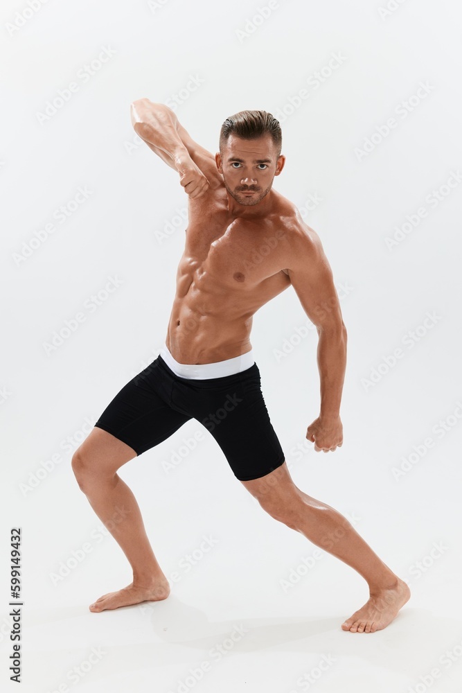 Obraz premium Man athletic body bodybuilder in briefs with naked torso abs full-length in the background, fitness classes. Advertising, sports, active lifestyle, competition, challenge concept.