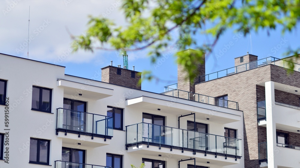Modern apartment buildings on a sunny day with a blue sky. Facade of a modern apartment building. Contemporary residential building exterior in the daylight. Modern apartment buildings on a sunny day with a blue sky. Facade of a modern apartment building. Contemporary residential building exterior in the daylight.