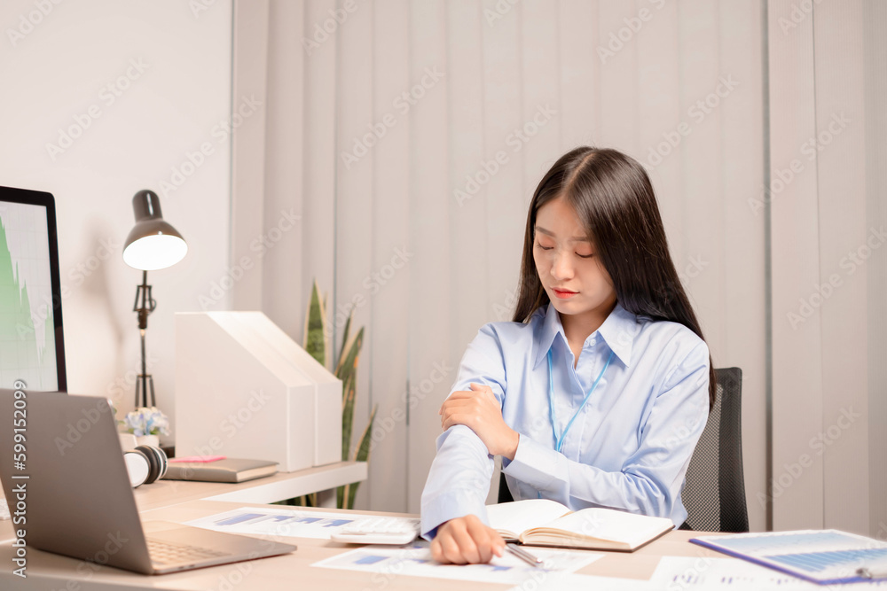 Businesswoman asia is sitting at workplace and feeling muscle aches from hard work. Businesswoman asia is sitting at workplace and feeling muscle aches from hard work.