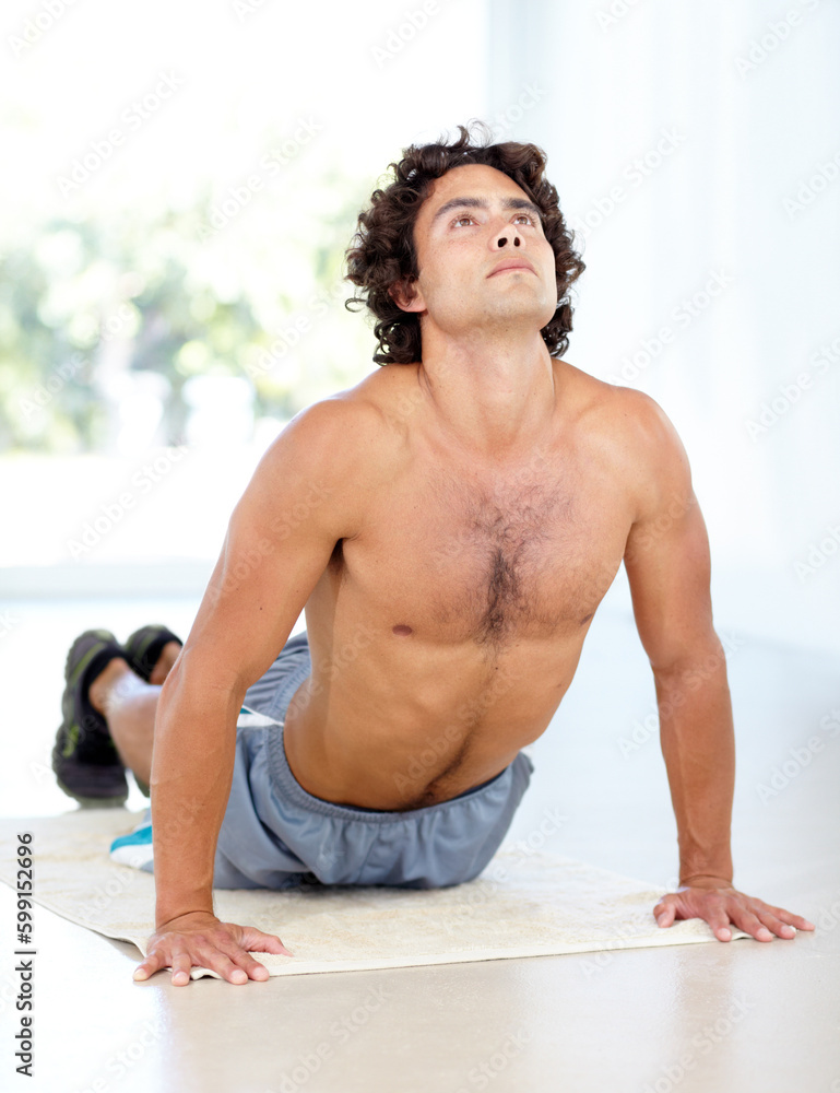 Obraz premium Yoga, man and cobra stretch in home for health, wellness and flexibility in house. Pilates, stretching and male person, yogi or athlete training, holistic workout and exercising for fitness on mat.