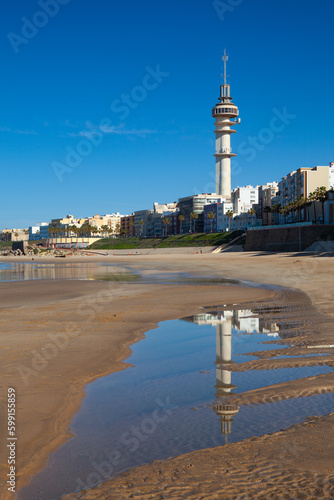 Television tower is reflected at low tide on the beach, Cadiz, S photo