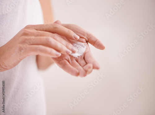 Hands  skincare and cream with a woman in studio on a gray background for moisturizing hydration. Natural beauty  cosmetics and wellness with a female model posing to apply lotion to her skin or palm