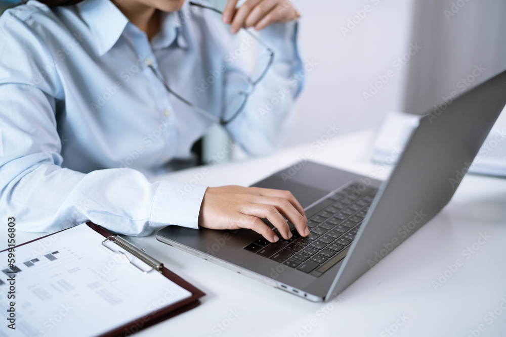 Asian Woman working by using a laptop computer Hands typing on keyboard. Working at office professional investor working new start up project Asian Woman working by using a laptop computer Hands typing on keyboard. Working at office professional investor working new start up project