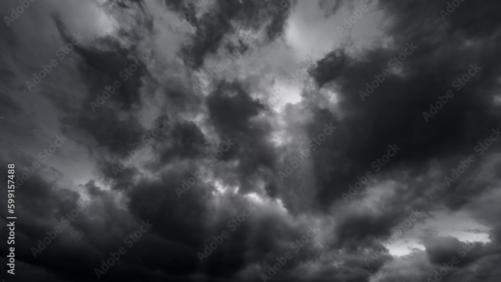 dark dramatic sky with black stormy clouds before rain or snow as abstract background, extreme weather, the sun shines through the clouds, high contrast photo - obrazy, fototapety, plakaty 