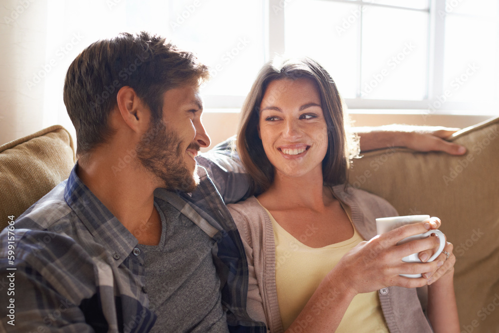 Coffee, love and couple smiling at each other or on a couch in the living room or bonding and conversation. Man, woman and communicating or affectionate with hot beverages or happy partners at home Coffee, love and couple smiling at each other or on a couch in the living room or bonding and conversation. Man, woman and communicating or affectionate with hot beverages or happy partners at home