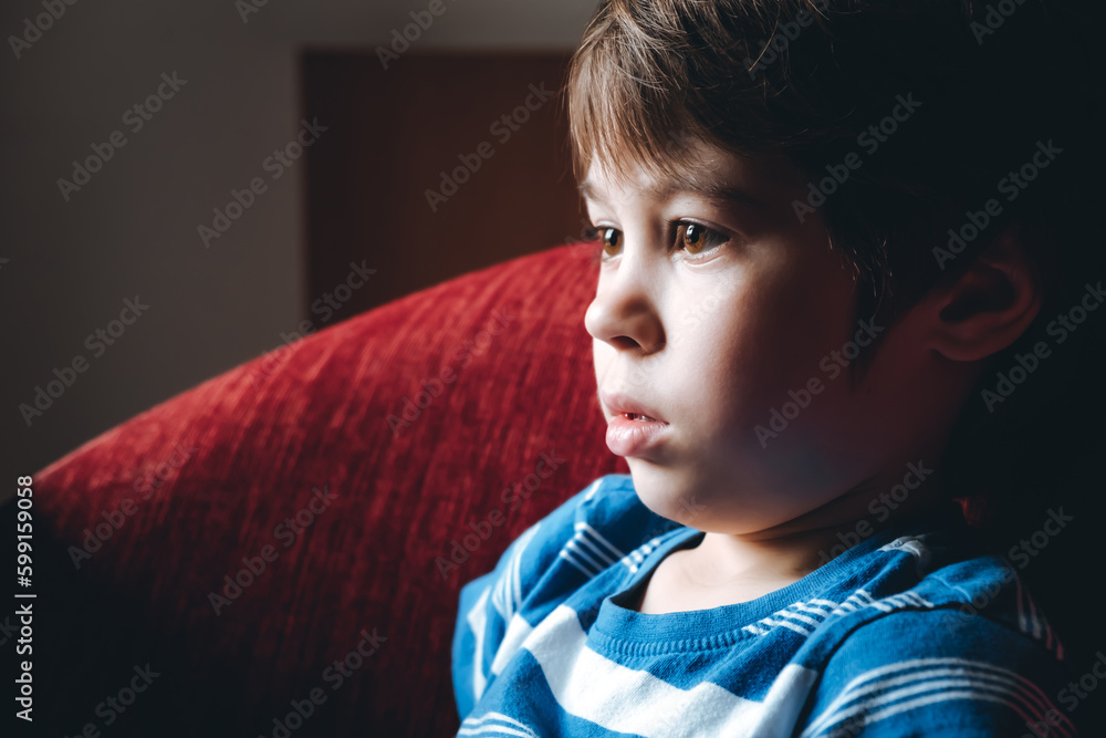 Tired eyes of 6 year boy looking at screen close-up. Child is watching ...