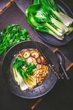Freshly prepared vegan ramen soup with noodles, shiitake mushrooms and steamed pak choi