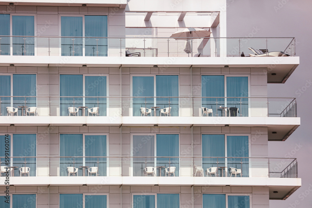 Plastic chairs on the balconies of a multi-storey building Plastic chairs on the balconies of a multi-storey building