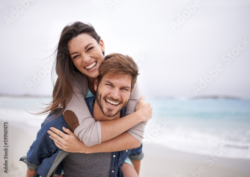 Love, piggyback and portrait of couple at a beach, hug and laughing while bonding outdoors. Face, embrace and happy man with woman at ocean for travel, freedom or vacation, holiday or Florida trip photo