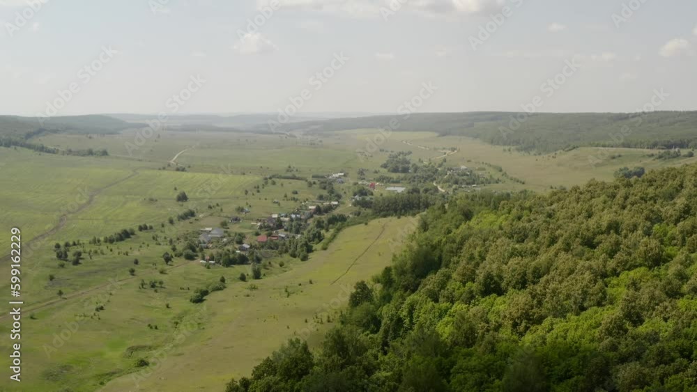 Nature and landmarks of Tatarstan republic in Russia. Fields, hills and forests in green. Private houses on the horizon. In the country. Mordovskaya Ivanovka village. Aerial drone view from above. Nature and landmarks of Tatarstan republic in Russia. Fields, hills and forests in green. Private houses on the horizon. In the country. Mordovskaya Ivanovka village. Aerial drone view from above.