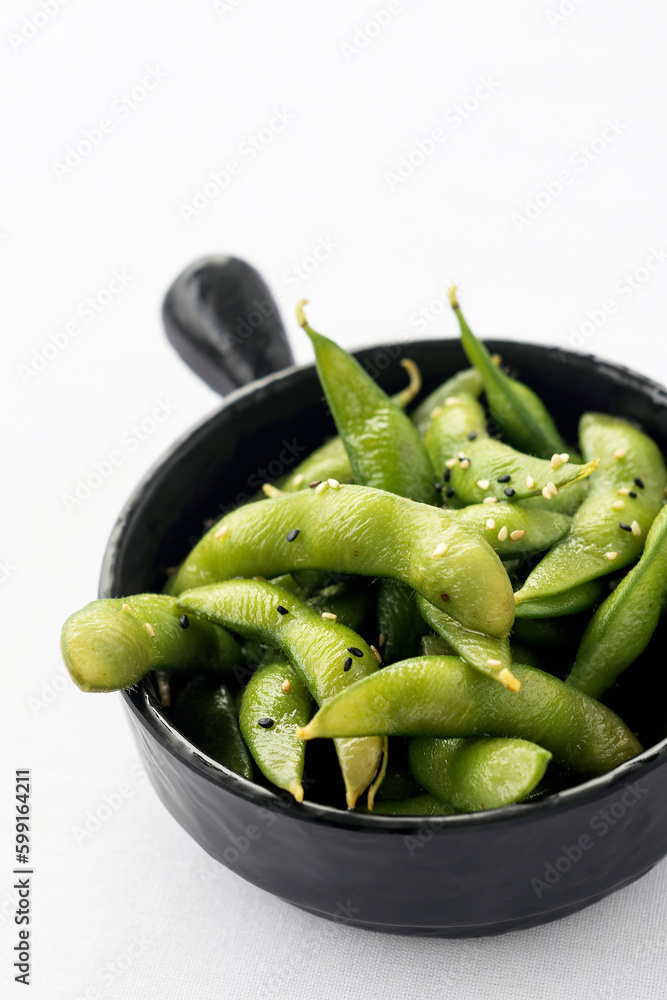 japanese edamame beans snack in black ceramic bowl on white background japanese edamame beans snack in black ceramic bowl on white background
